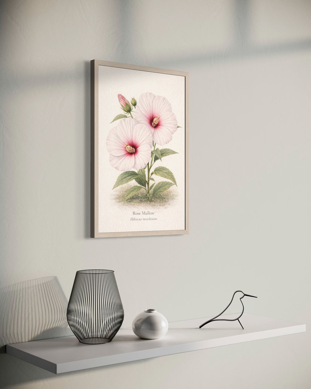 Framed botanical print of a pink flower on a wall above a shelf with decorative items.