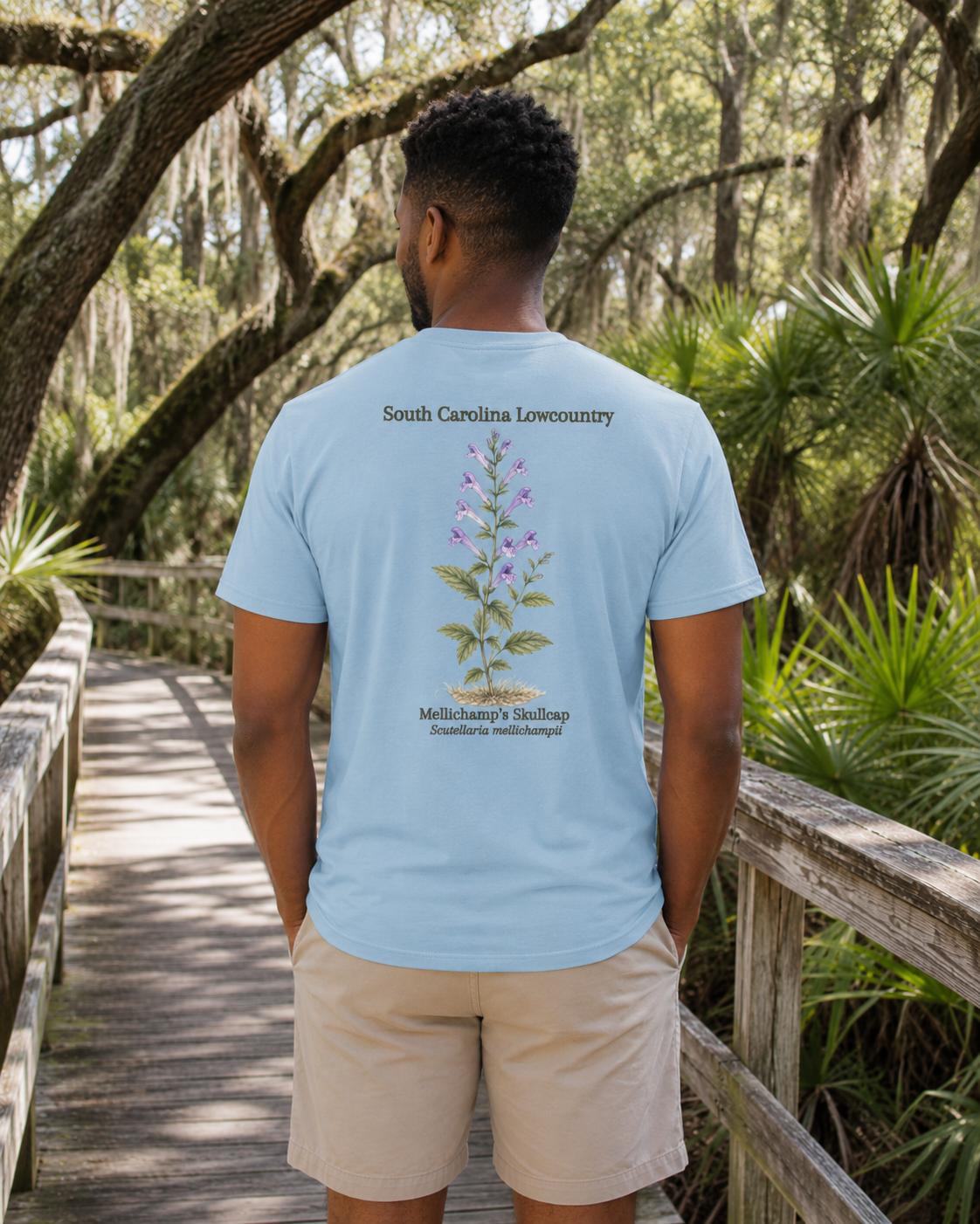 Man wearing a light blue t-shirt with botanical design in a natural setting