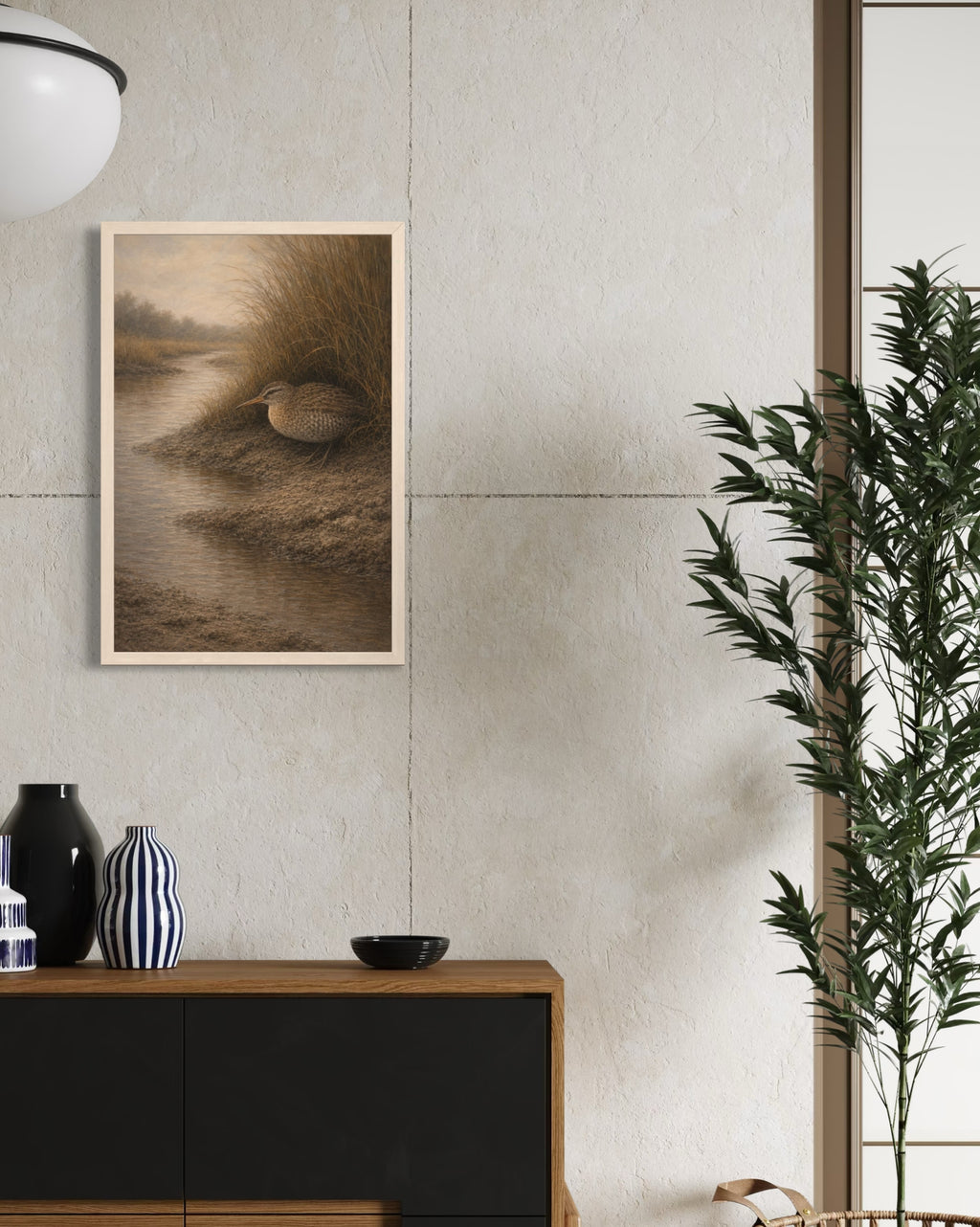 Framed artwork on a wall with a vase and plant in the foreground