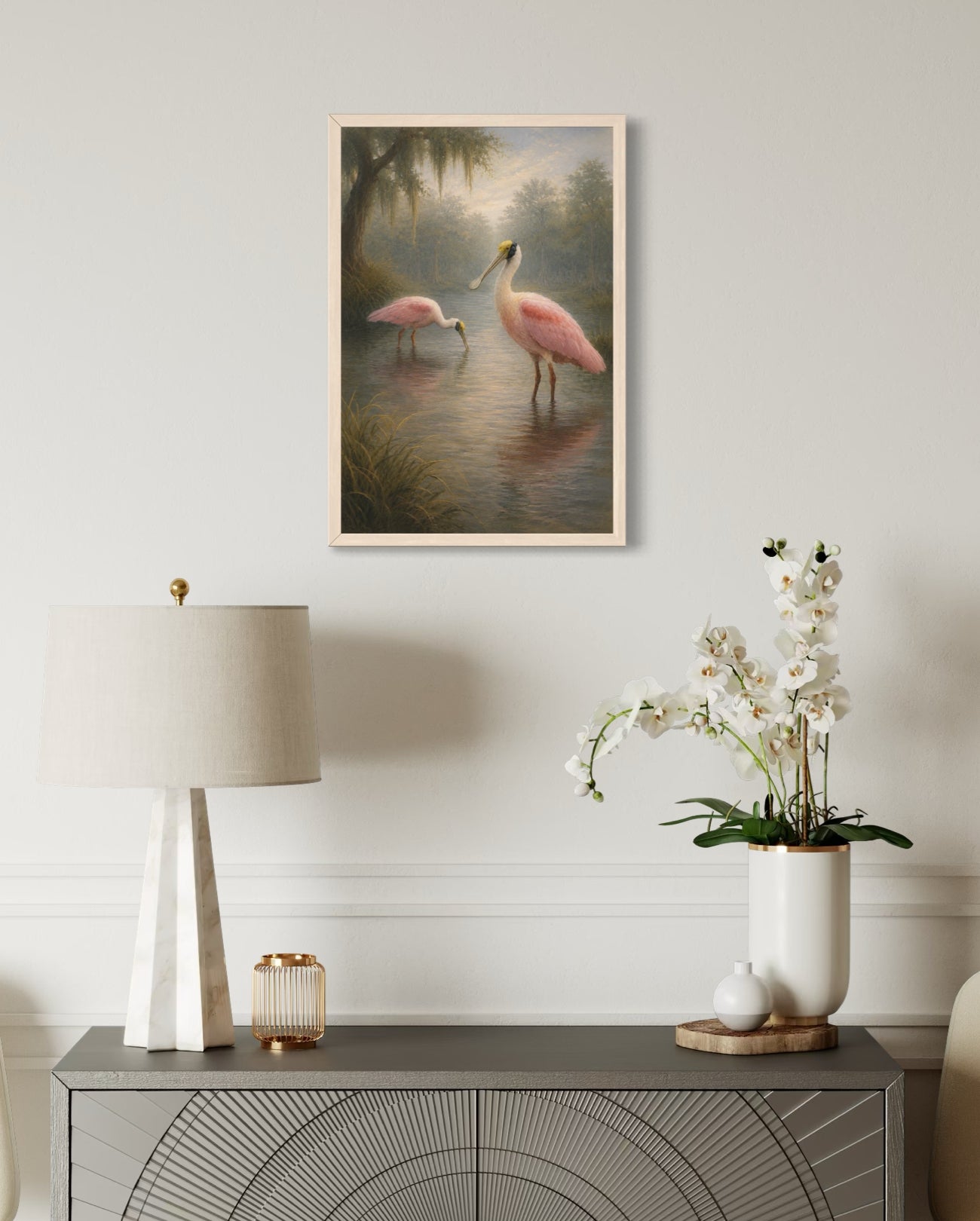 Decorative interior with a painting of pink flamingos, a lamp, and a vase with flowers on a side table.