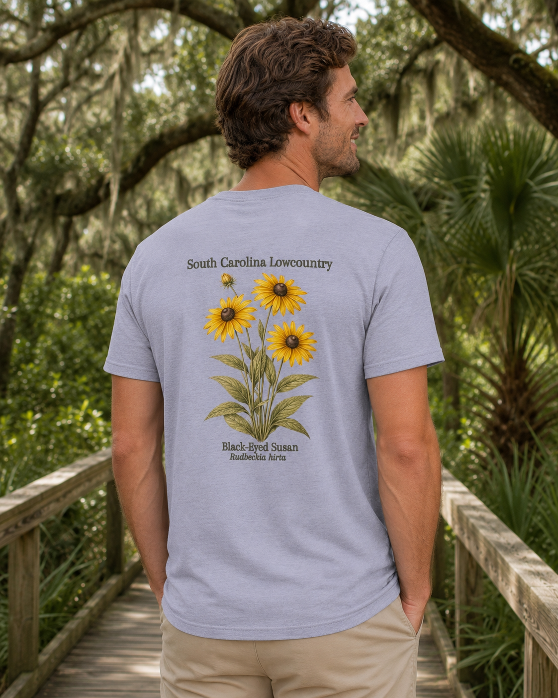 Man wearing a light blue t-shirt with sunflower design in a natural setting