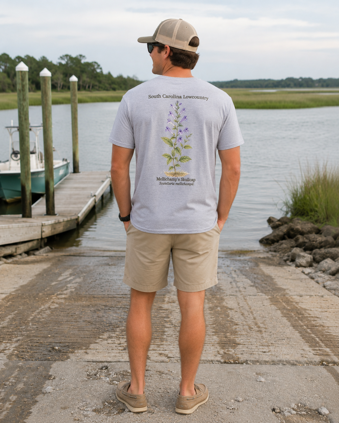 Man wearing a gray t-shirt with a plant design by a dock