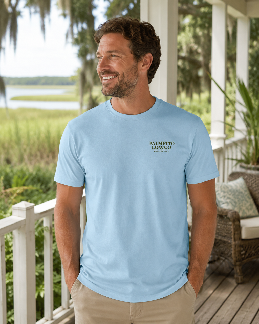 Man wearing a light blue t-shirt with a logo on a porch