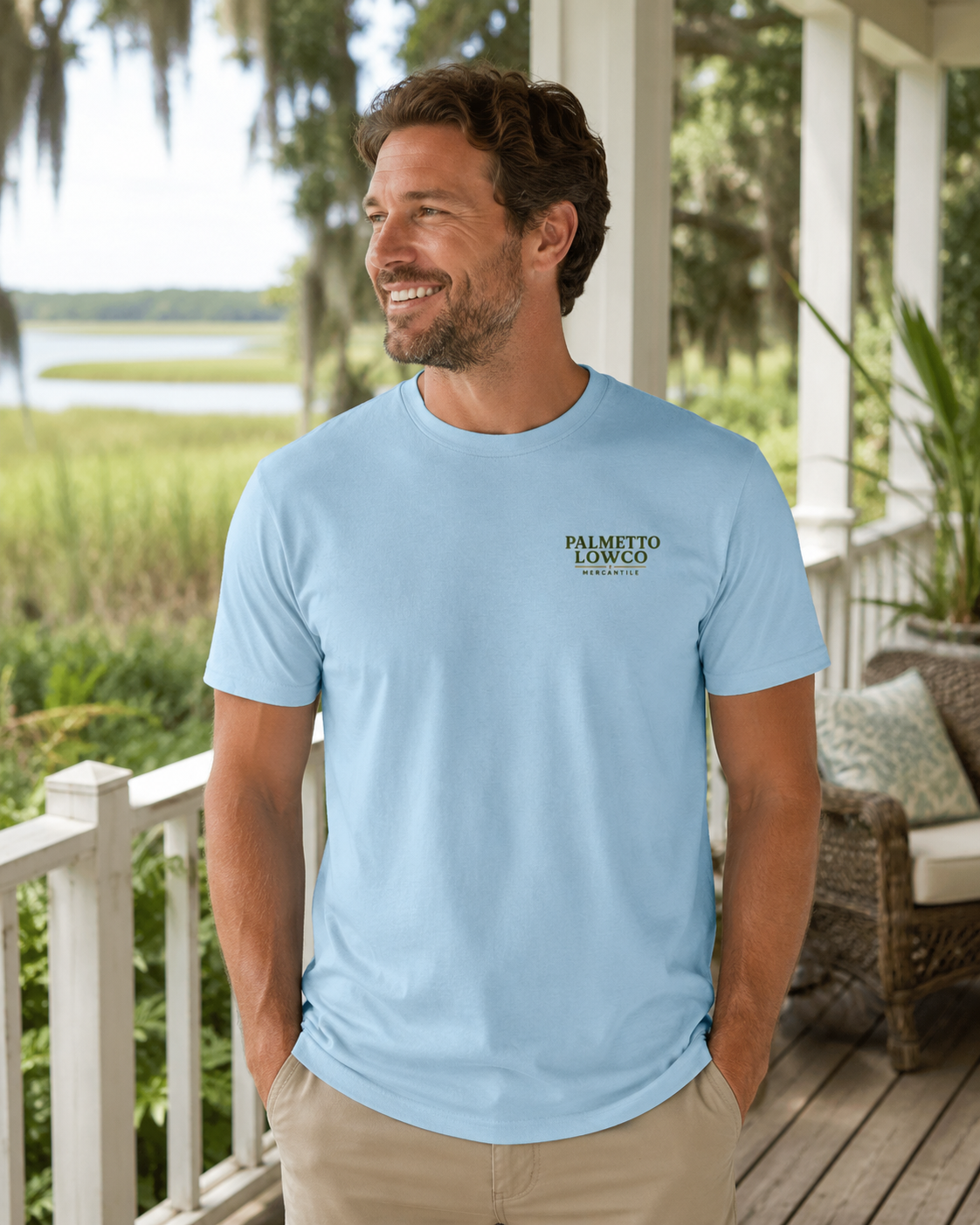 Man wearing a light blue t-shirt with a logo on a porch