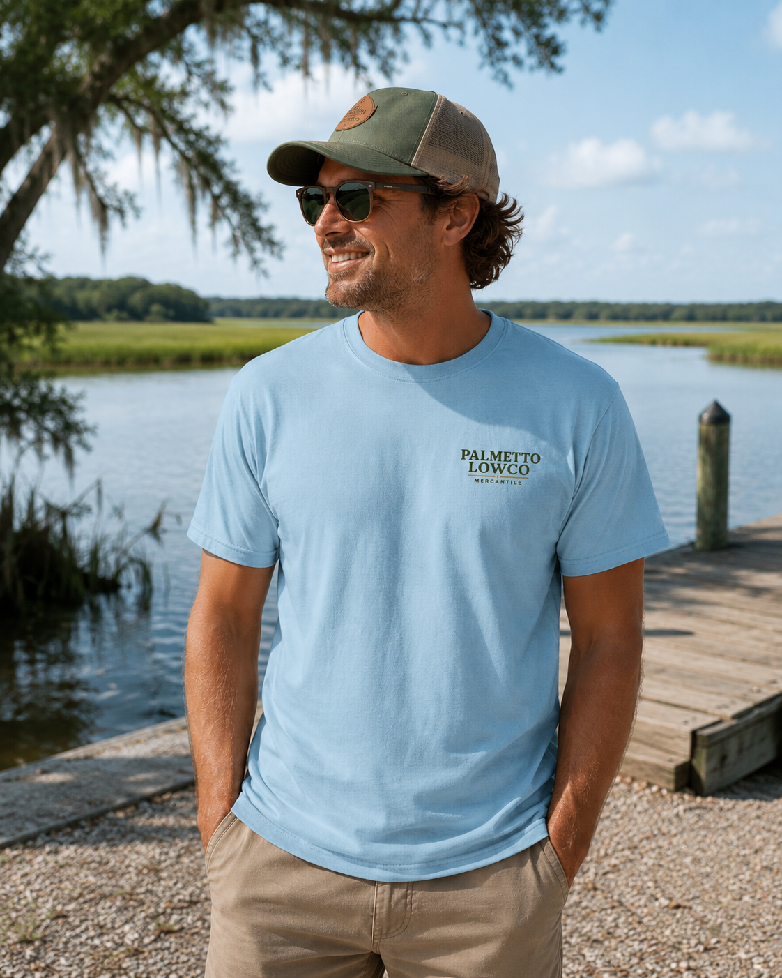 Man wearing a light blue t-shirt with 'Palmetto Lowcountry' logo by a waterfront.