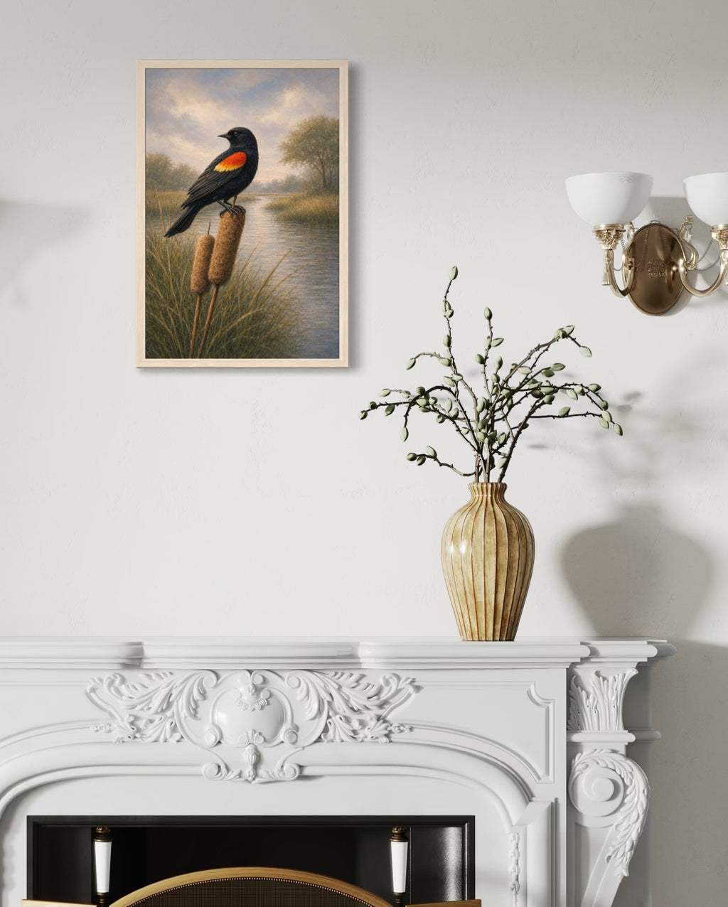 Framed artwork of a bird on a branch above a white fireplace with a vase of branches.